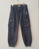 Pair of black pants on a white surface with a gray background